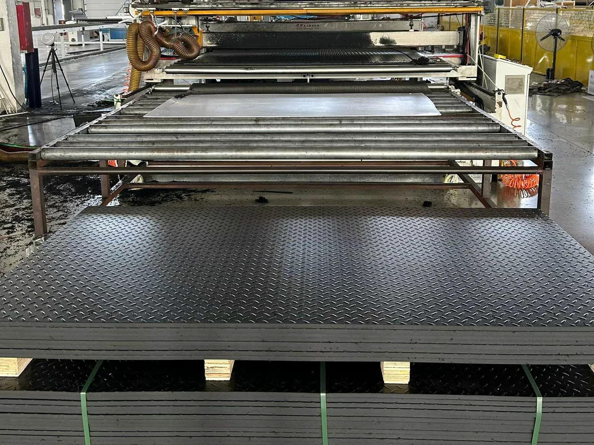 Black textured mats stacked with straps in a workshop
