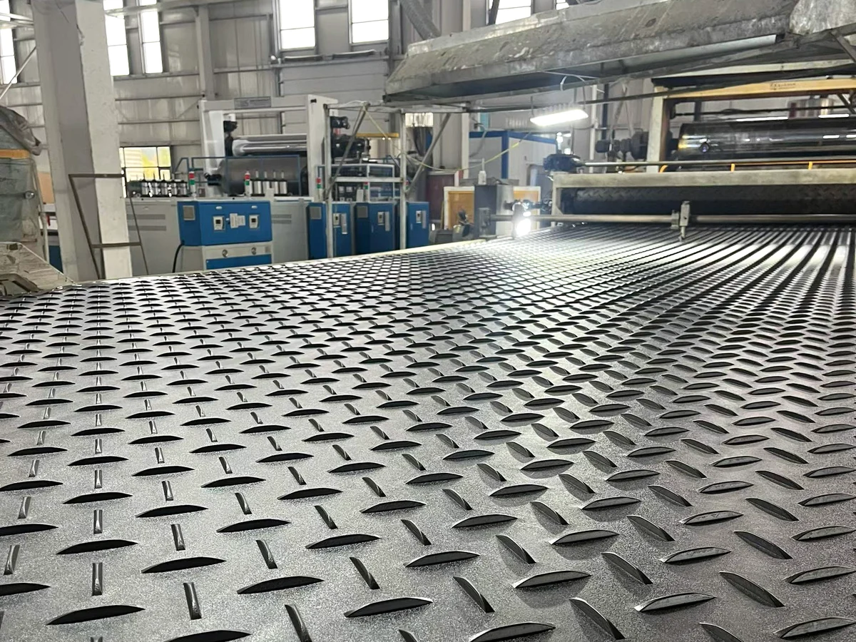 Textured black panel on rollers in front of production equipment